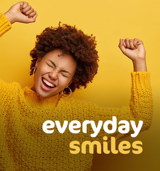 A woman dances in her bright yellow sweater as she has her everyday Smiles with Needs.
